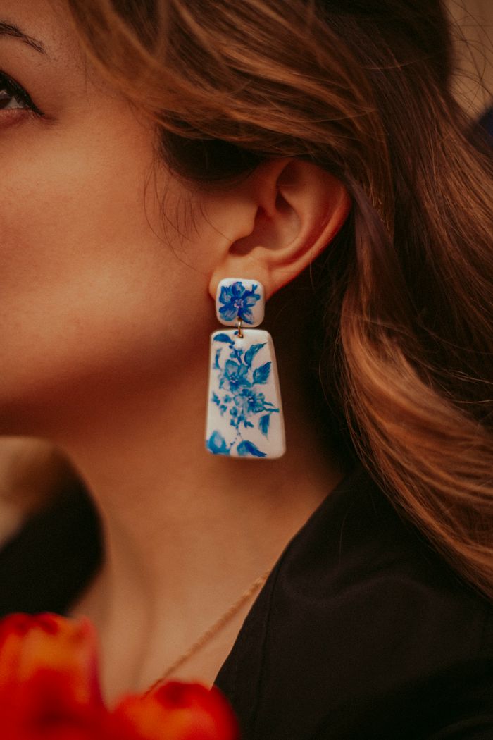 Crafting Captivating Headlines: Your awesome post title goes here Fashion-forward close-up showcasing elegant blue floral earrings, ideal for artistic jewelry promotions.